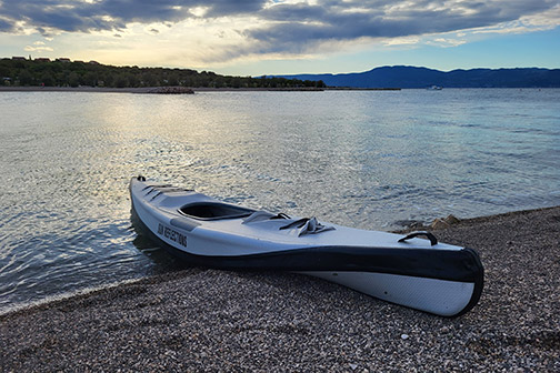 Sun Reflections Kajak halb im Wasser, fotografiert am Strand in Kroatien